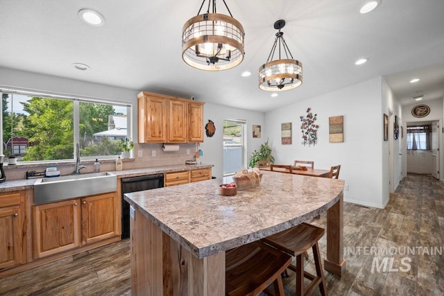 kitchen with black dishwasher, dark wood-style floors, a chandelier, recessed lighting, and a kitchen breakfast bar