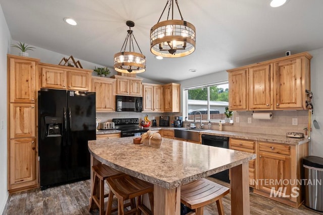kitchen with black appliances, a sink, lofted ceiling, light countertops, and decorative backsplash