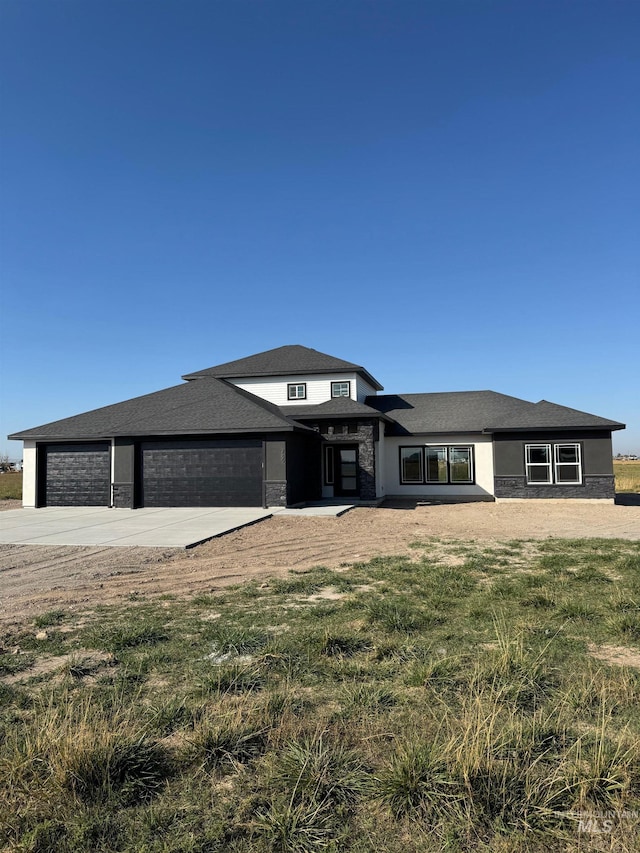 prairie-style house featuring a front yard and a garage