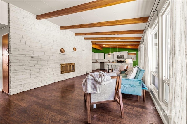 living room featuring plenty of natural light, wood finished floors, and a stone fireplace