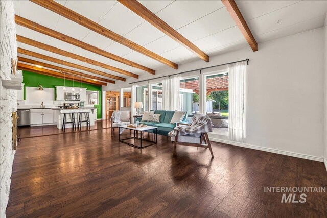 living room with baseboards, vaulted ceiling with beams, and dark wood-type flooring
