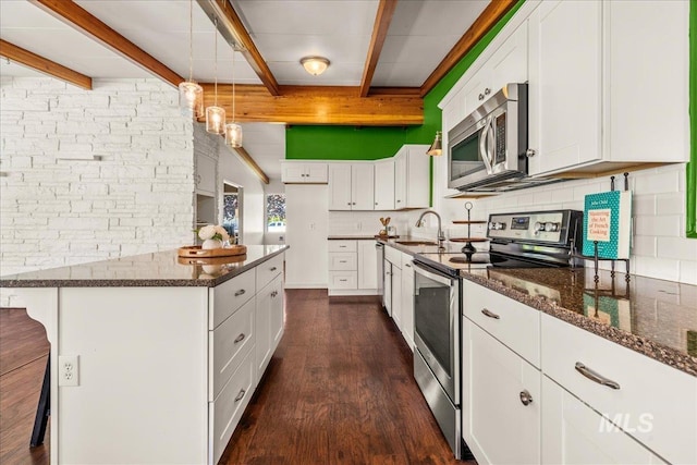 kitchen with dark wood-style flooring, beam ceiling, dark stone counters, stainless steel appliances, and decorative backsplash