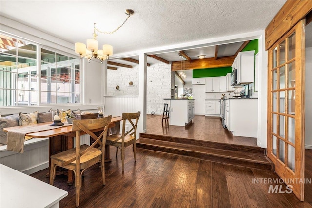 dining area featuring an inviting chandelier, dark wood-style flooring, brick wall, breakfast area, and a textured ceiling