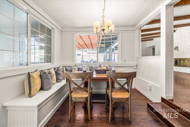 dining area with wood finished floors, a chandelier, and breakfast area