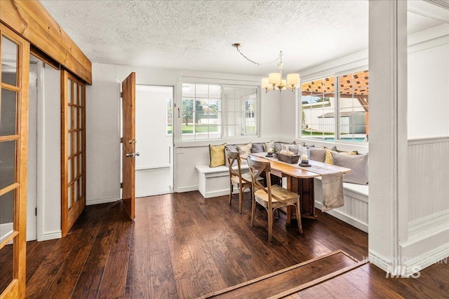dining space featuring a textured ceiling, a notable chandelier, hardwood / wood-style floors, and breakfast area