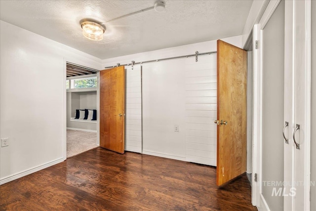 unfurnished bedroom featuring a textured ceiling and wood finished floors