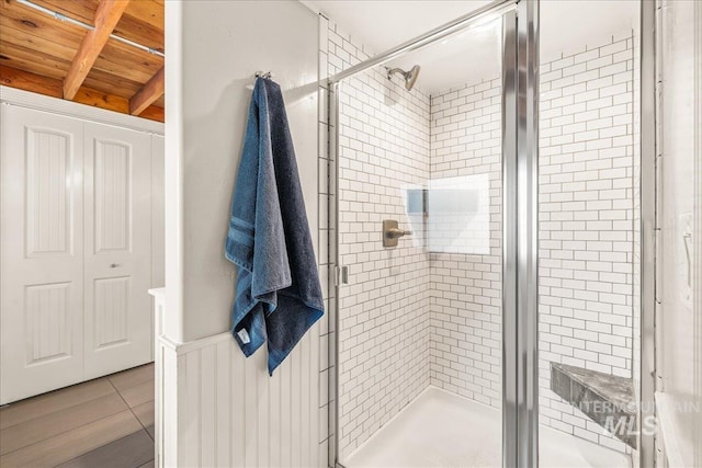 full bathroom featuring beamed ceiling, a shower stall, wood ceiling, and tile patterned floors