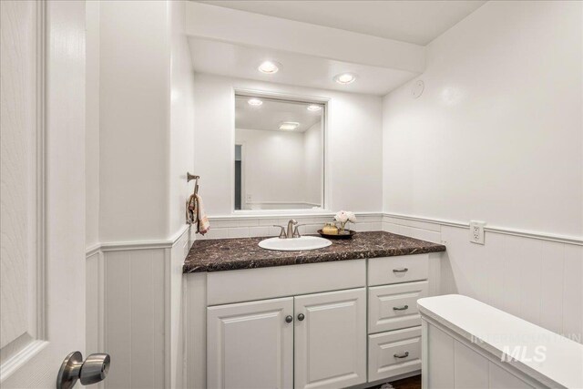 bathroom with vanity, recessed lighting, and a wainscoted wall