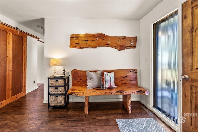 mudroom with baseboards, a barn door, and wood finished floors