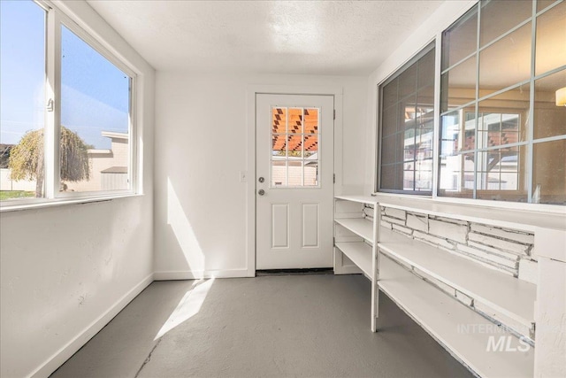 interior space with baseboards and a textured ceiling