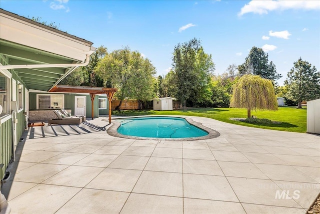 view of swimming pool with a storage shed, a patio, an outbuilding, and a lawn