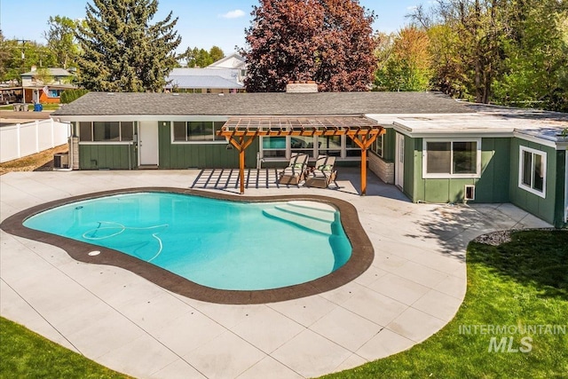 outdoor pool with fence and a patio
