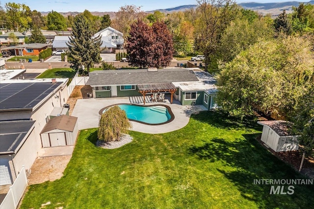 pool featuring a yard, an outbuilding, and a storage shed