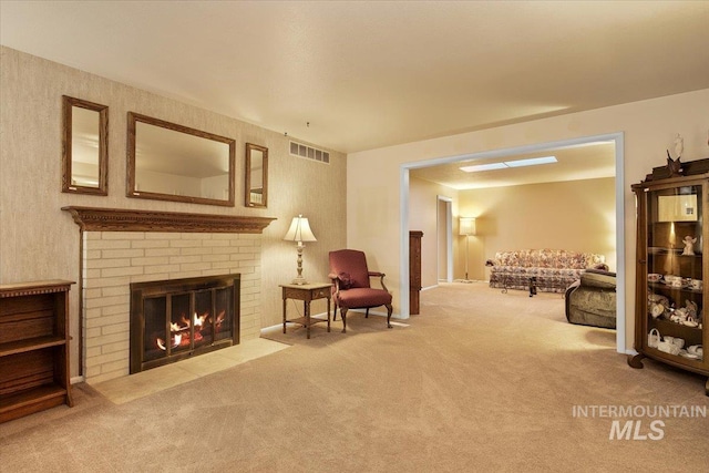 living area featuring a brick fireplace and carpet flooring