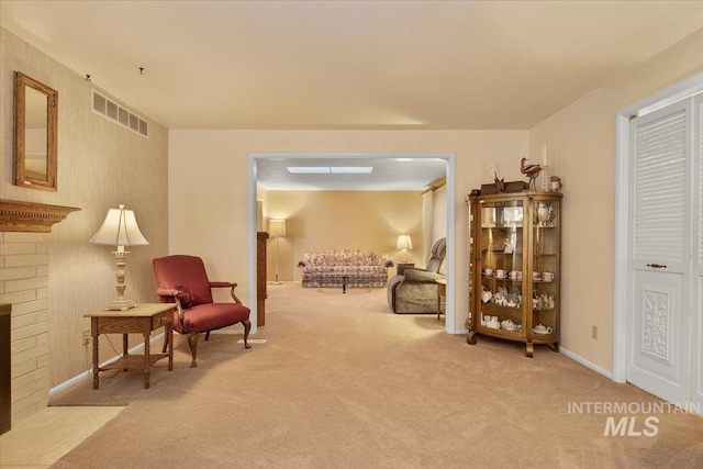 living area with light carpet and a brick fireplace