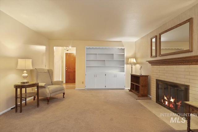 sitting room with light colored carpet, a notable chandelier, and a fireplace