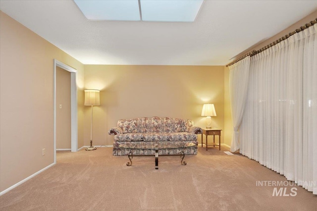 living area featuring a skylight and carpet