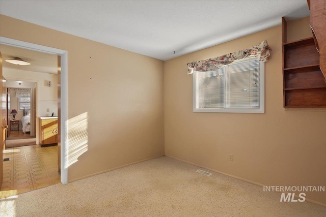 unfurnished room featuring a wealth of natural light and carpet flooring