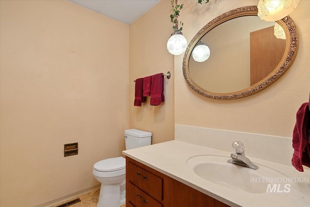 bathroom with toilet, tile patterned floors, and vanity