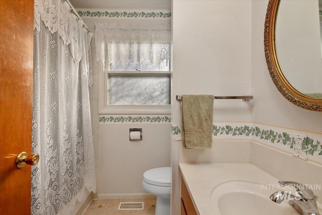 bathroom with curtained shower, tile patterned floors, toilet, and vanity