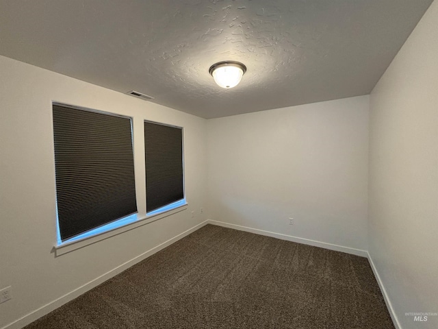 5619 E Bollo St, Nampa, ID 83687 - spare room featuring dark carpet, a textured ceiling, and baseboards