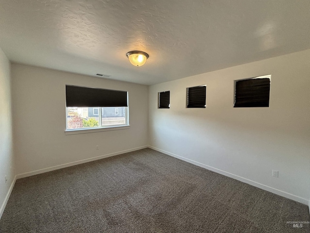5619 E Bollo St, Nampa, ID 83687 - spare room featuring dark carpet, baseboards, and a textured ceiling