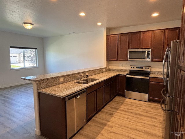 5619 E Bollo St, Nampa, ID 83687 - kitchen with appliances with stainless steel finishes, a sink, light wood-style flooring, light stone countertops, and recessed lighting