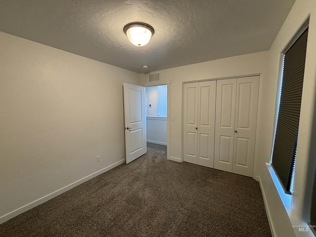 5619 E Bollo St, Nampa, ID 83687 - unfurnished bedroom featuring dark colored carpet, baseboards, a textured ceiling, and a closet