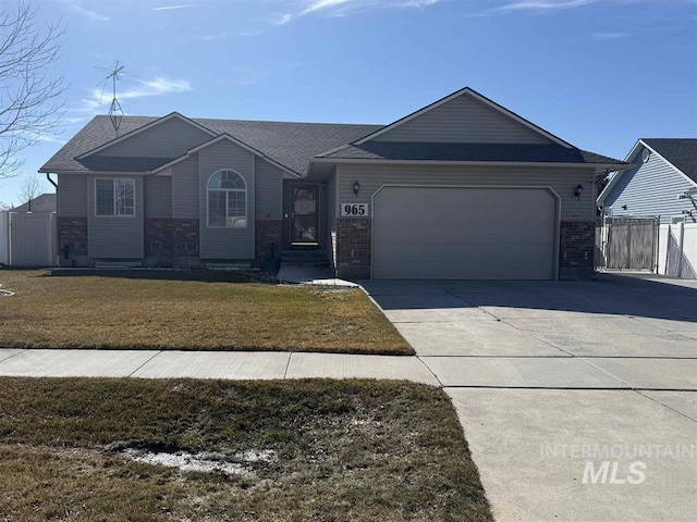 ranch-style home featuring a garage, driveway, a gate, fence, and a front lawn