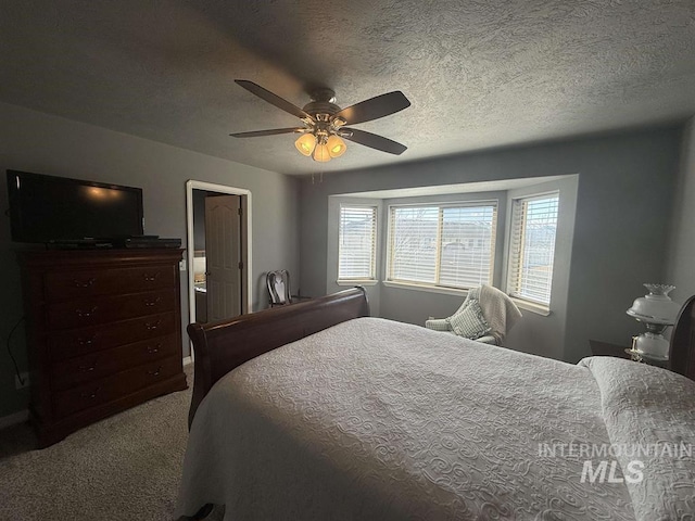 bedroom featuring a textured ceiling, a ceiling fan, and carpet flooring