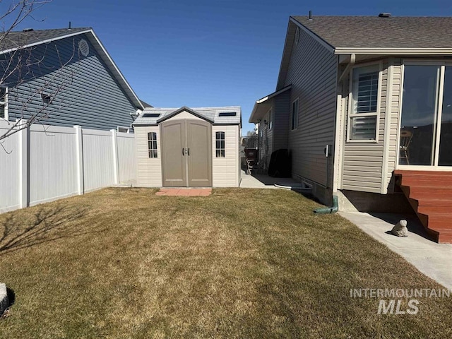 view of yard with an outdoor structure, fence, and a shed