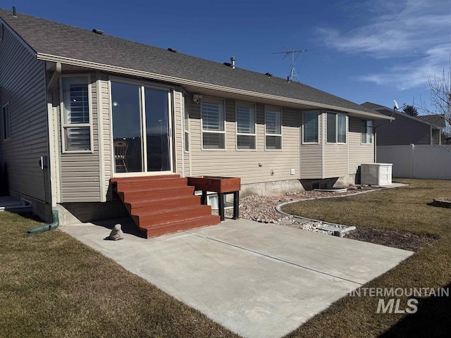 back of house featuring entry steps, central AC unit, a shingled roof, fence, and a yard