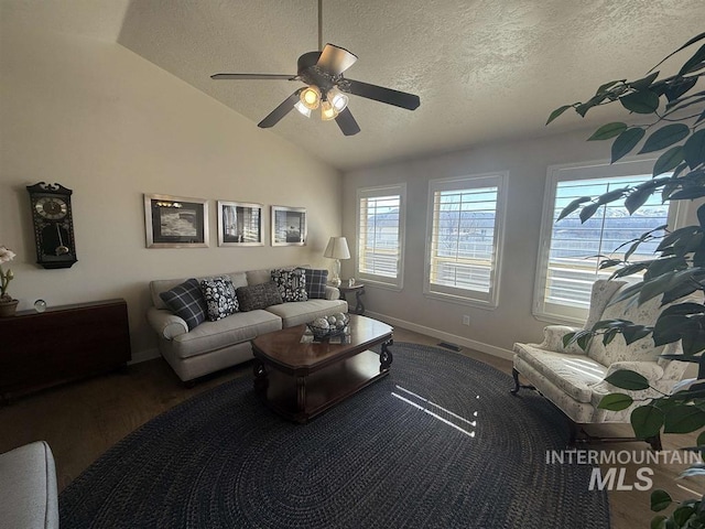 living area with lofted ceiling, visible vents, plenty of natural light, and wood finished floors