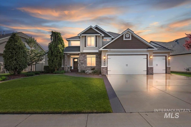 craftsman-style house featuring a lawn, an attached garage, stone siding, and driveway