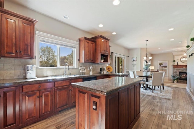 kitchen with a sink, hardwood / wood-style flooring, recessed lighting, decorative backsplash, and a kitchen island