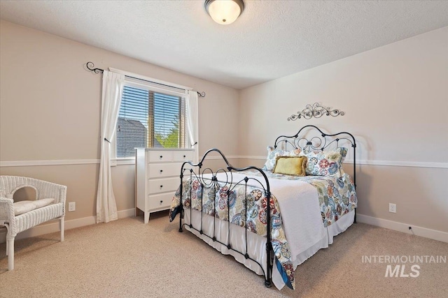 bedroom with carpet flooring, a textured ceiling, and baseboards