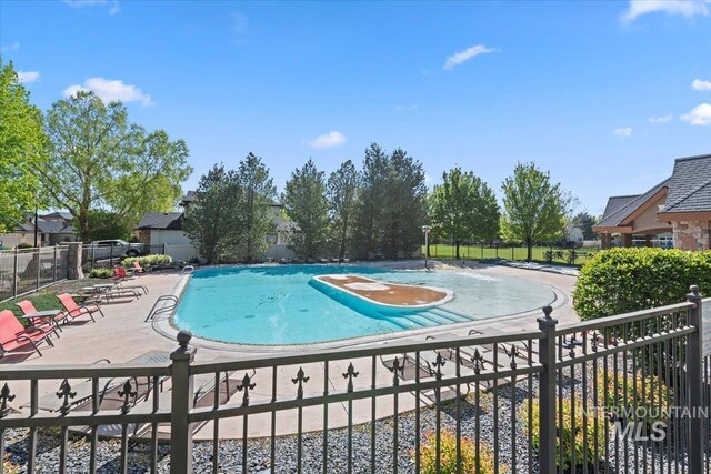 community pool featuring fence and a patio