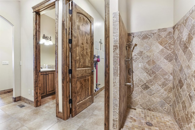full bathroom featuring visible vents, a tile shower, tile patterned flooring, and vanity
