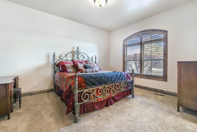 carpeted bedroom with visible vents and baseboards