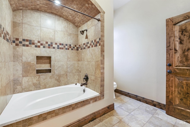 bathroom with toilet, shower / bathtub combination, lofted ceiling, and baseboards