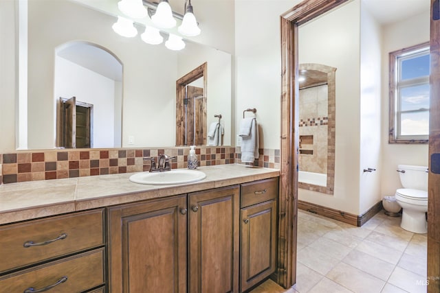 bathroom featuring vanity, tile patterned floors, tasteful backsplash, toilet, and a shower