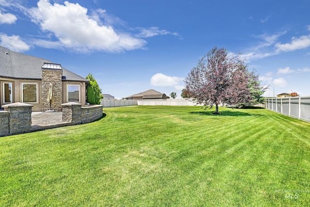 view of yard featuring fence and a patio
