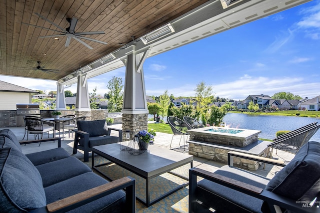 view of patio with area for grilling, an outdoor living space with a fire pit, ceiling fan, a water view, and grilling area