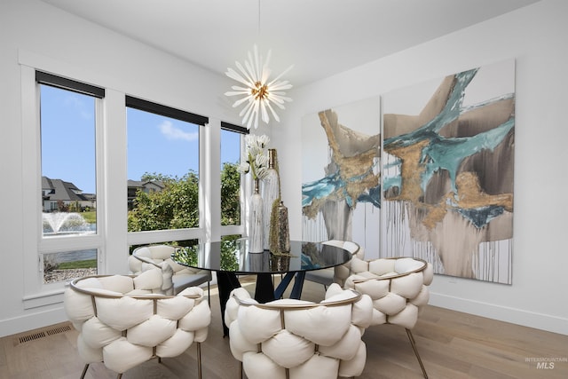 dining area featuring hardwood / wood-style flooring and an inviting chandelier