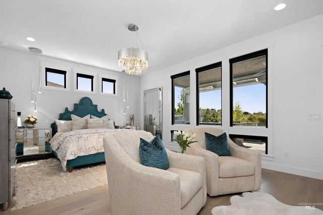 bedroom with a chandelier and light wood-type flooring