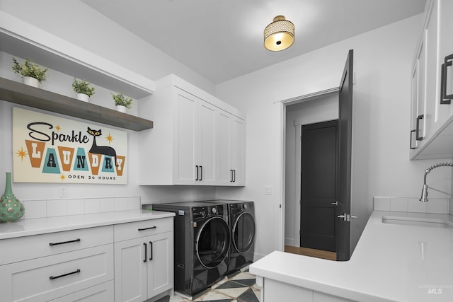 washroom featuring cabinets, independent washer and dryer, and sink