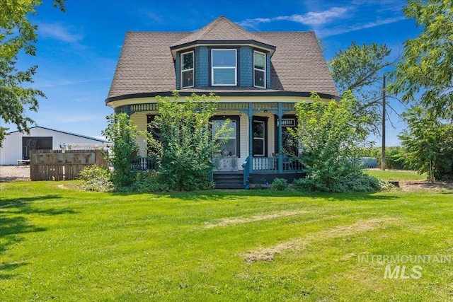 victorian-style house with a front yard and a porch