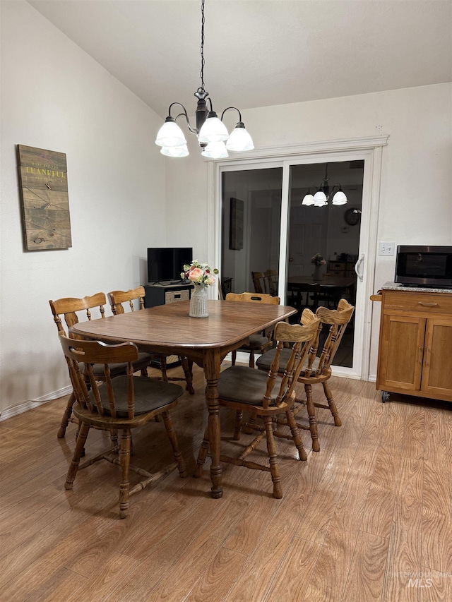 dining room with lofted ceiling and light hardwood / wood-style floors