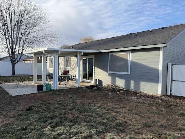 back of property featuring a patio and a lawn