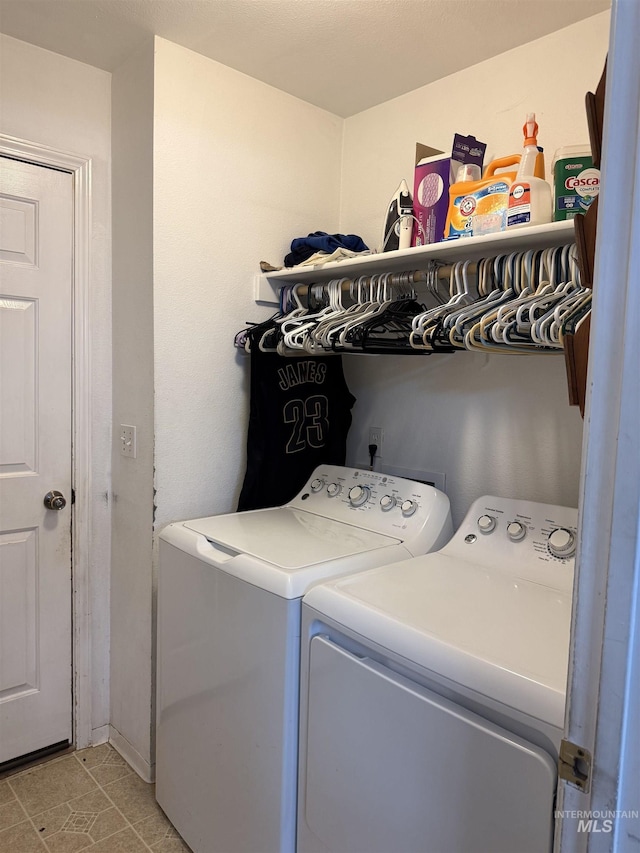 laundry room featuring washing machine and dryer and light tile patterned flooring